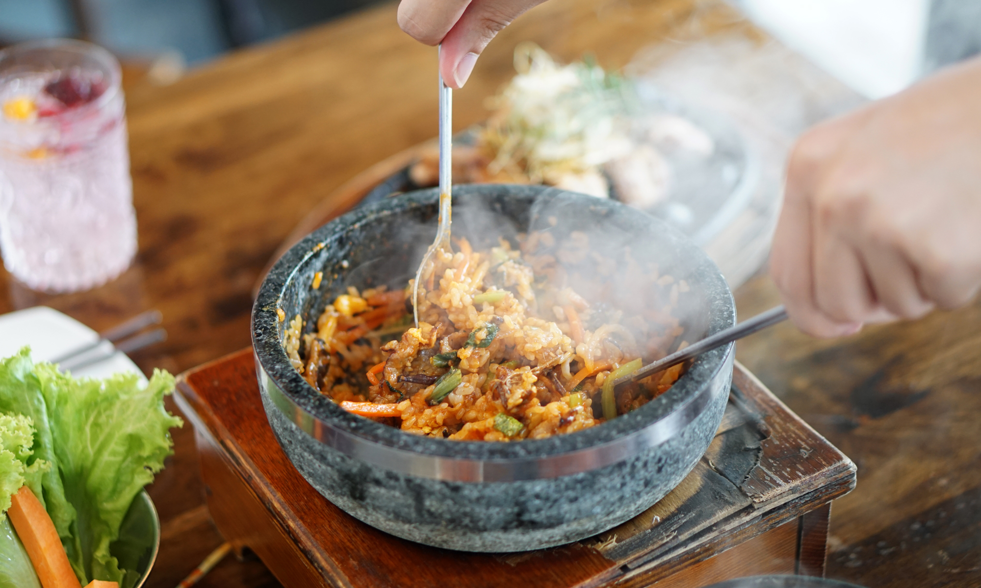 https://www.21oak.com/wp-content/uploads/sites/7/2020/02/dolsot-bibimbap-in-dolsot-being-stirred-on-table.jpg?p=1