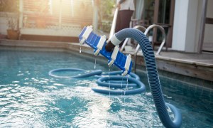 Pool vacuum sticking out of an outdoor pool