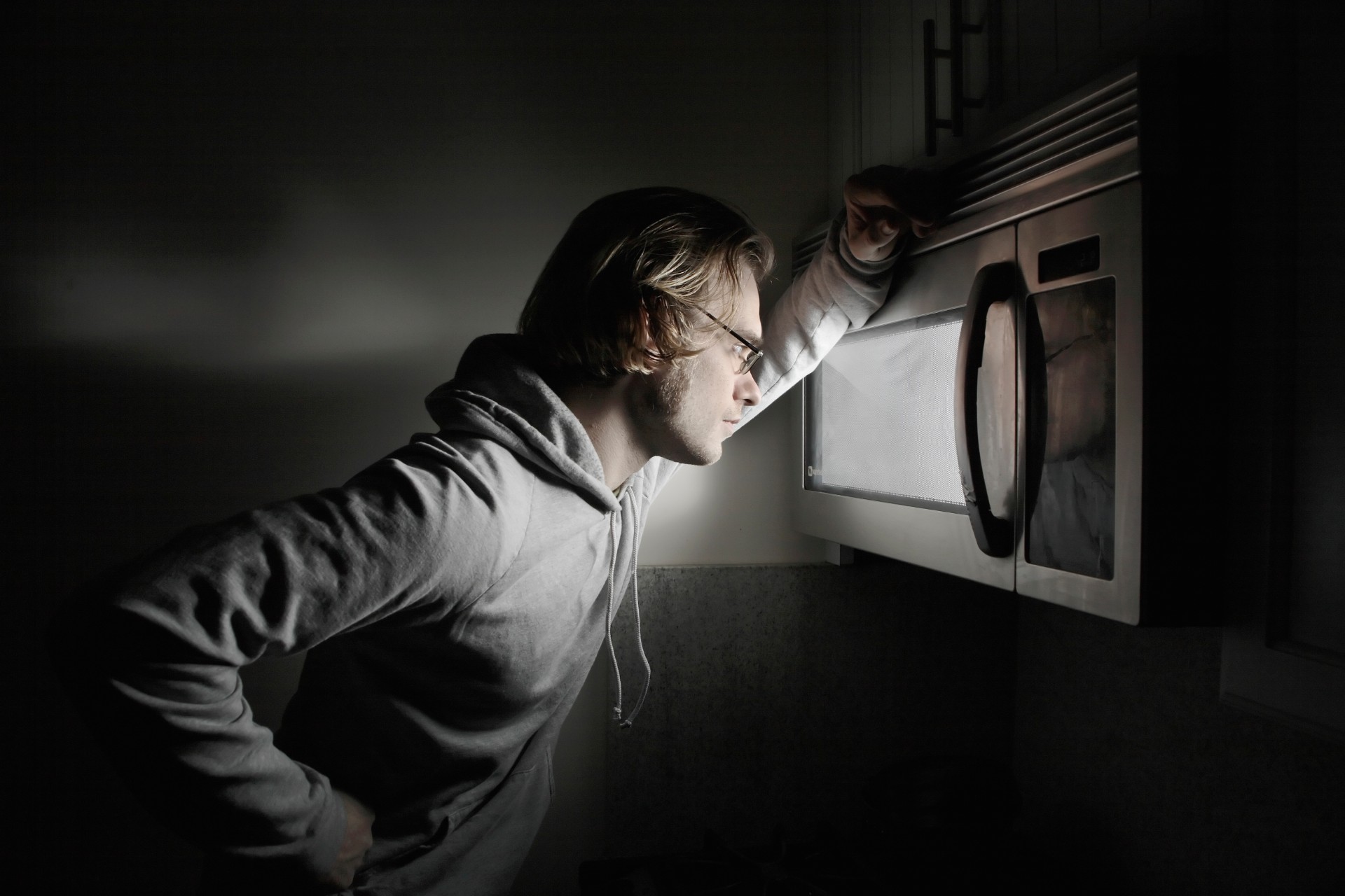 Man looking into microwave oven