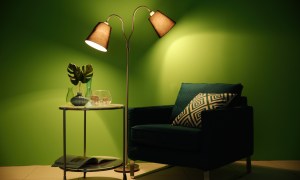 Green chair in room with green walls and lamp