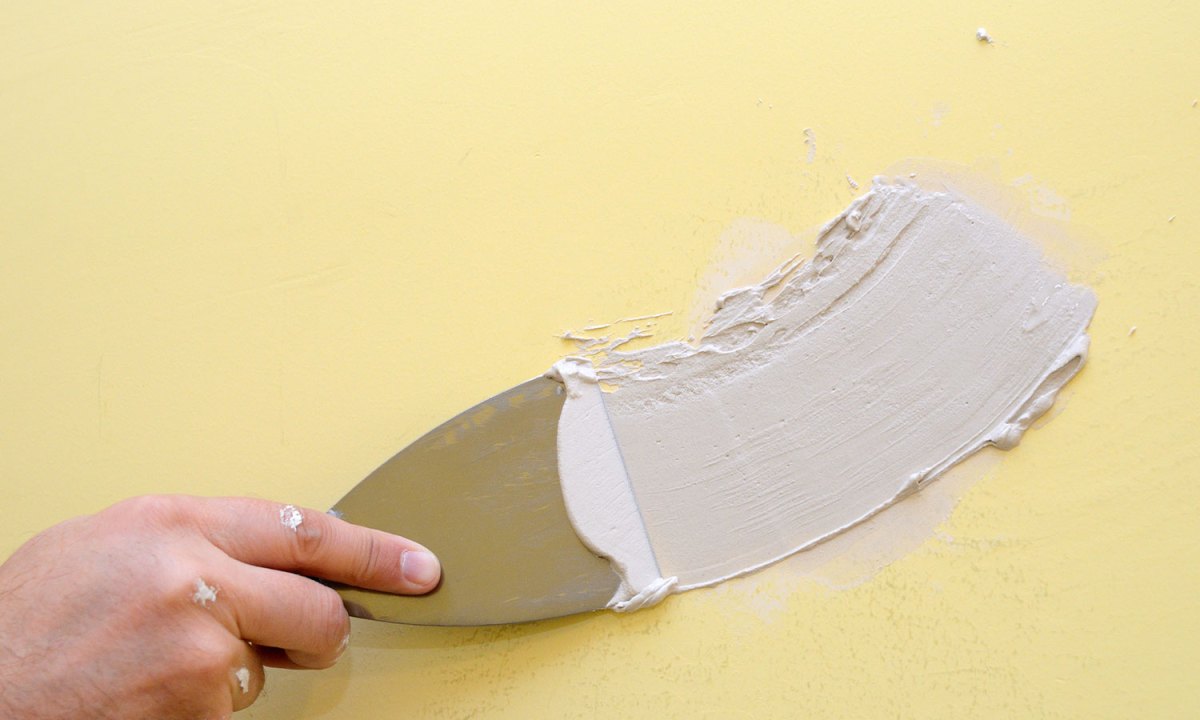 Person spackling yellow wall