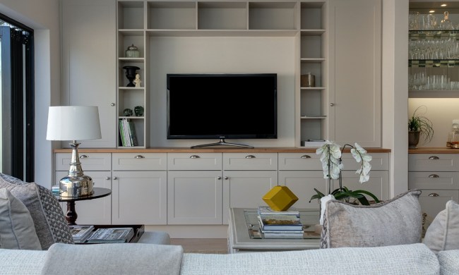 Contemporary living room with furniture, shelves, and large TV