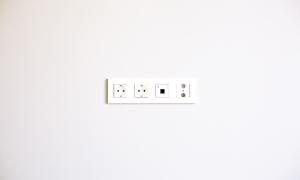 White wall with white strip of electrical outlets