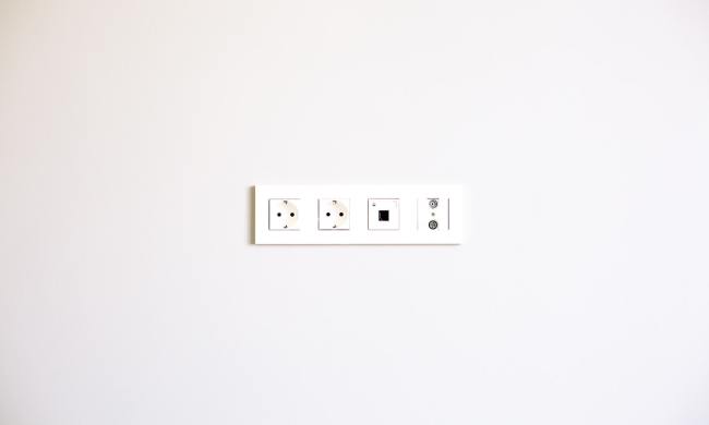 White wall with white strip of electrical outlets