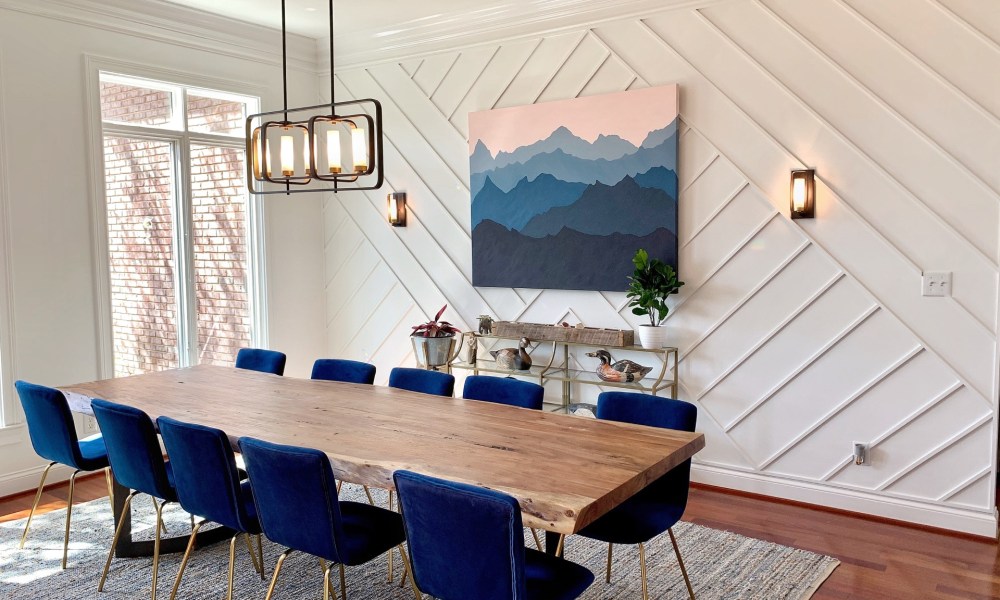 Modern dining room with blue chairs and rug.