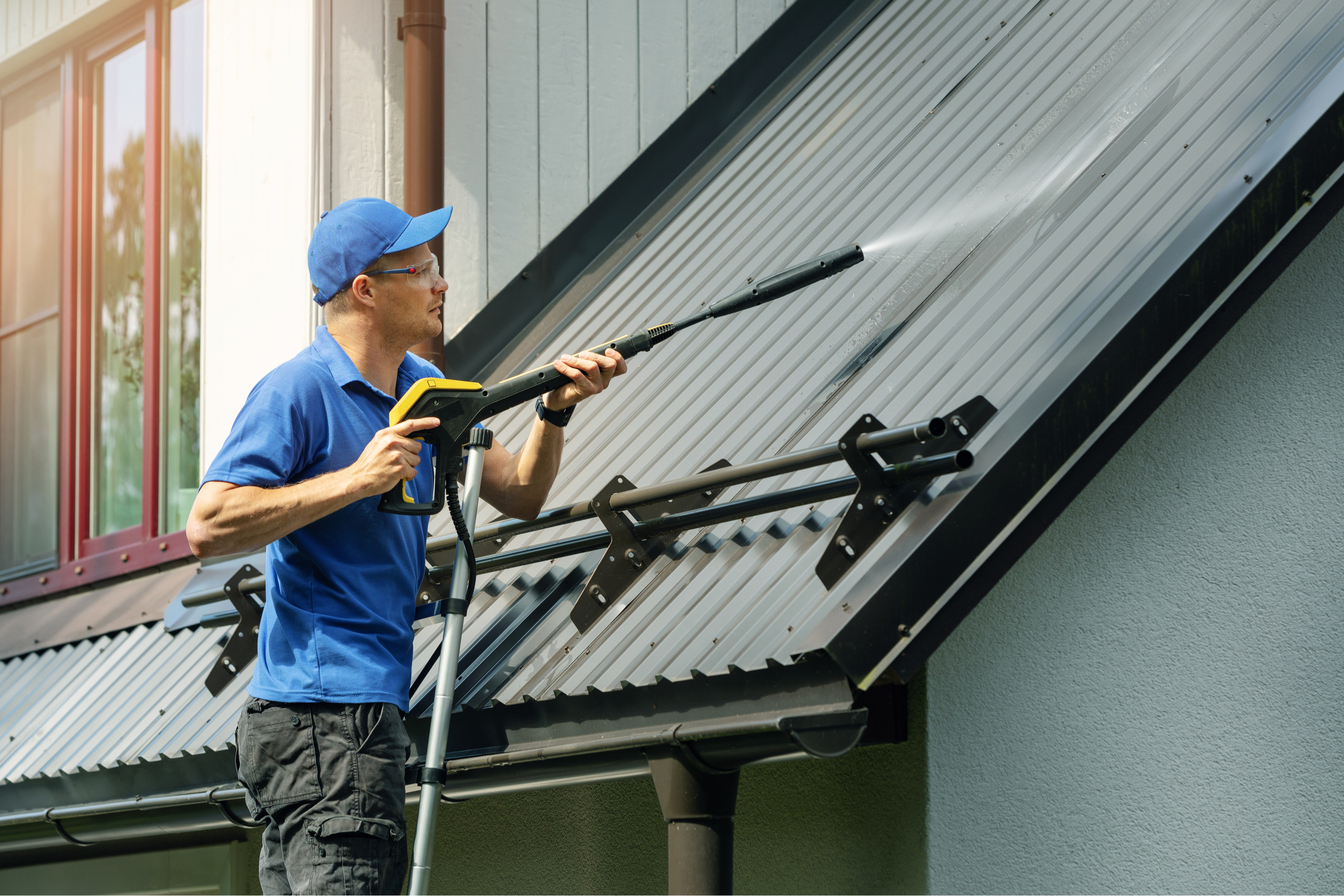 Man spraying roof with power washer