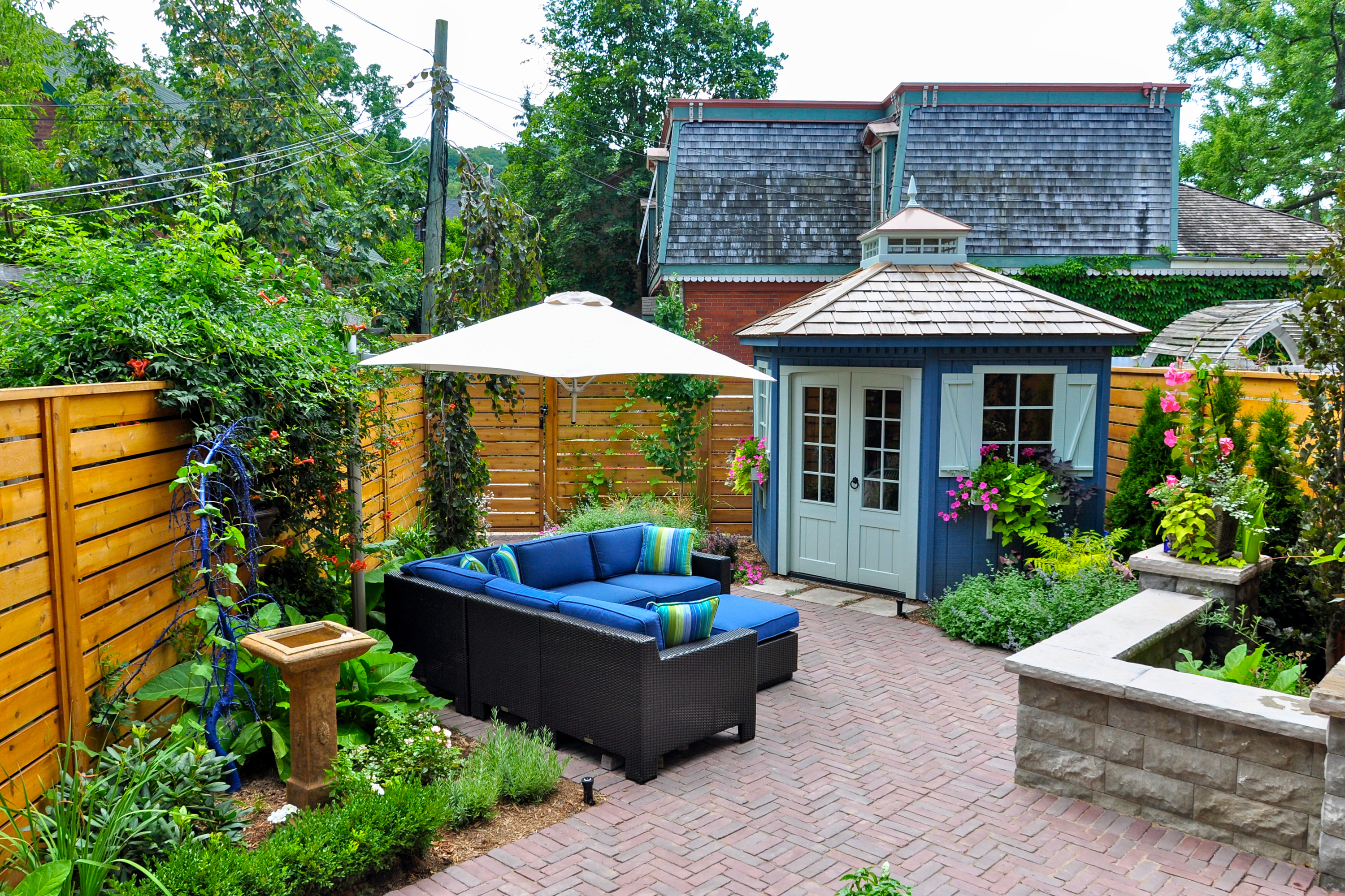 Backyard patio with pavers, plants, and furniture