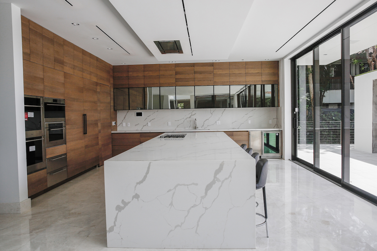 midcentruy modern kitchen with wood cabinets and marble iland