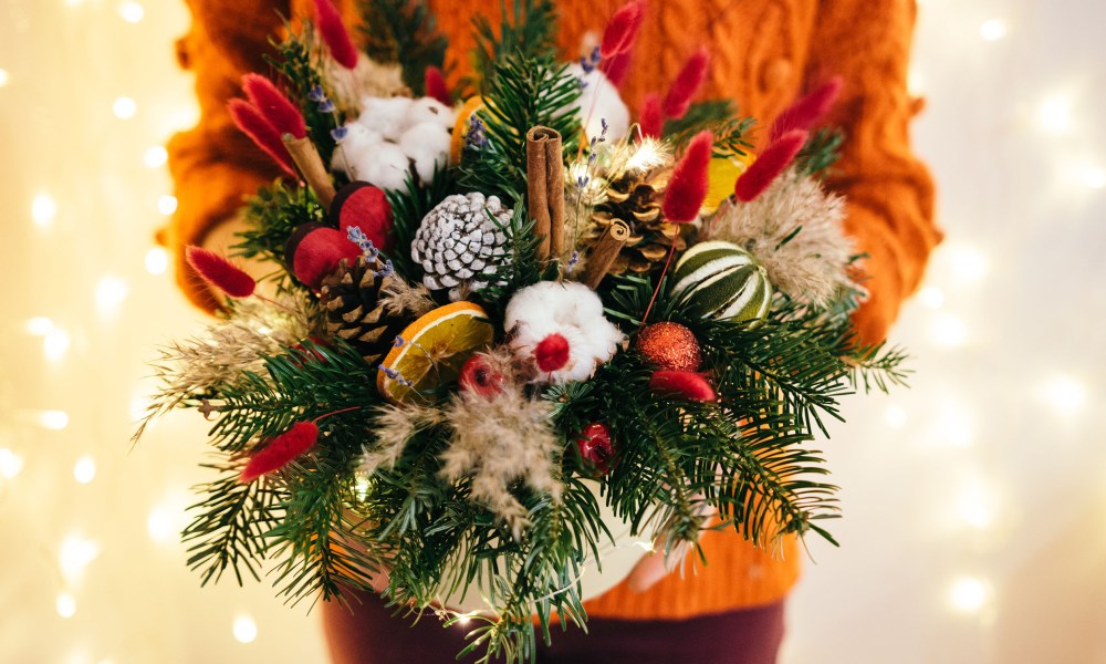 Person holding a festive Christmas centerpiece