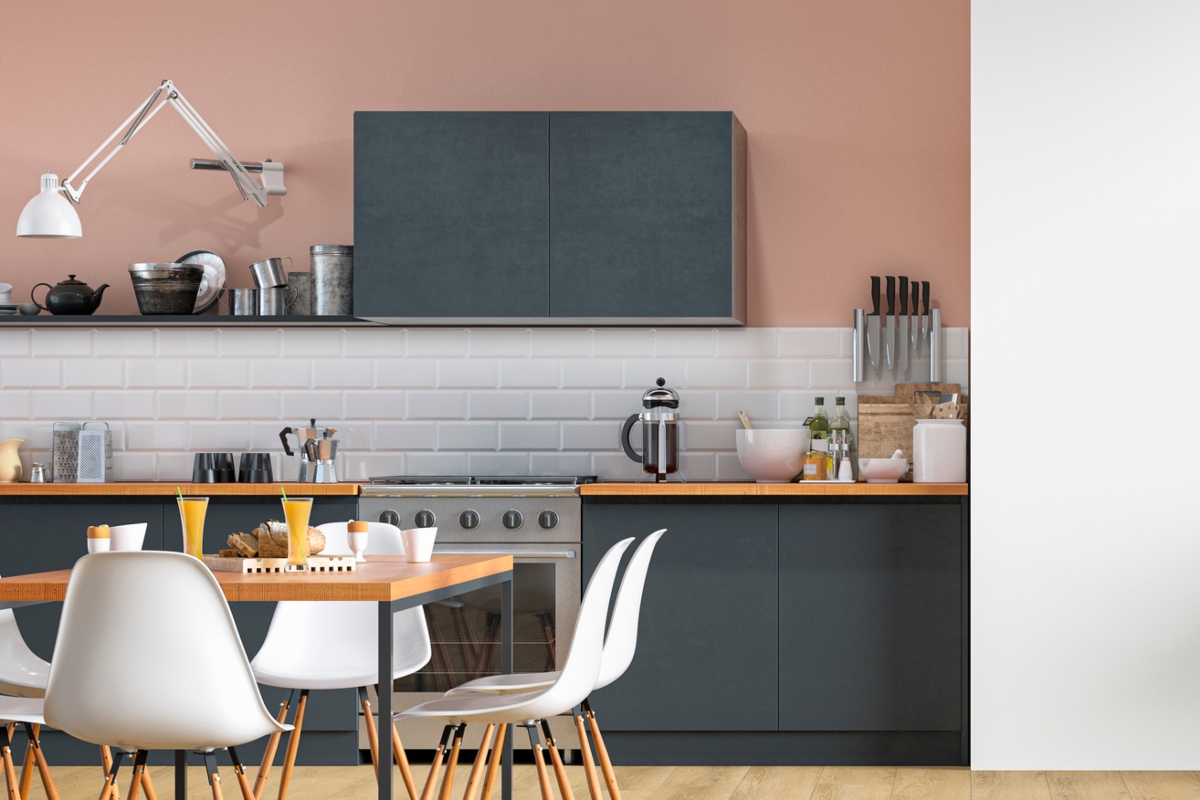 Pink kitchen walls with black cabinets and white backsplash