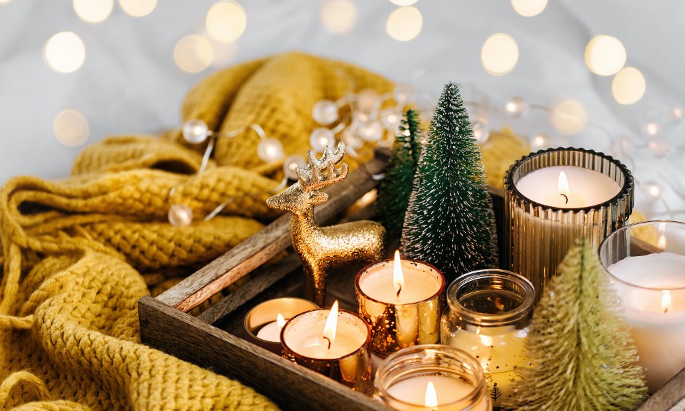 Burning candles and christmas decorations on wooden tray.