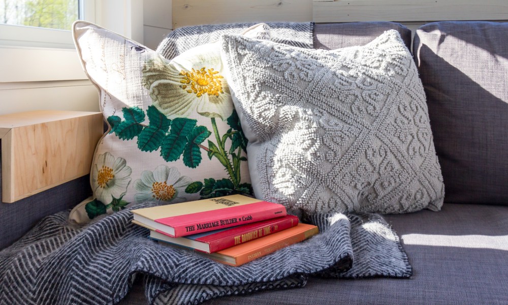 Textured throw pillows on a couch with books