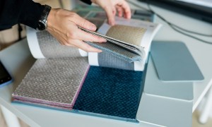 Person flipping through texture swatches for home design