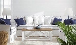 White sofa with navy accents in front of shiplap wall