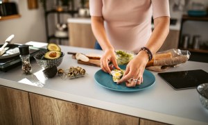 Person preparing avocado toast