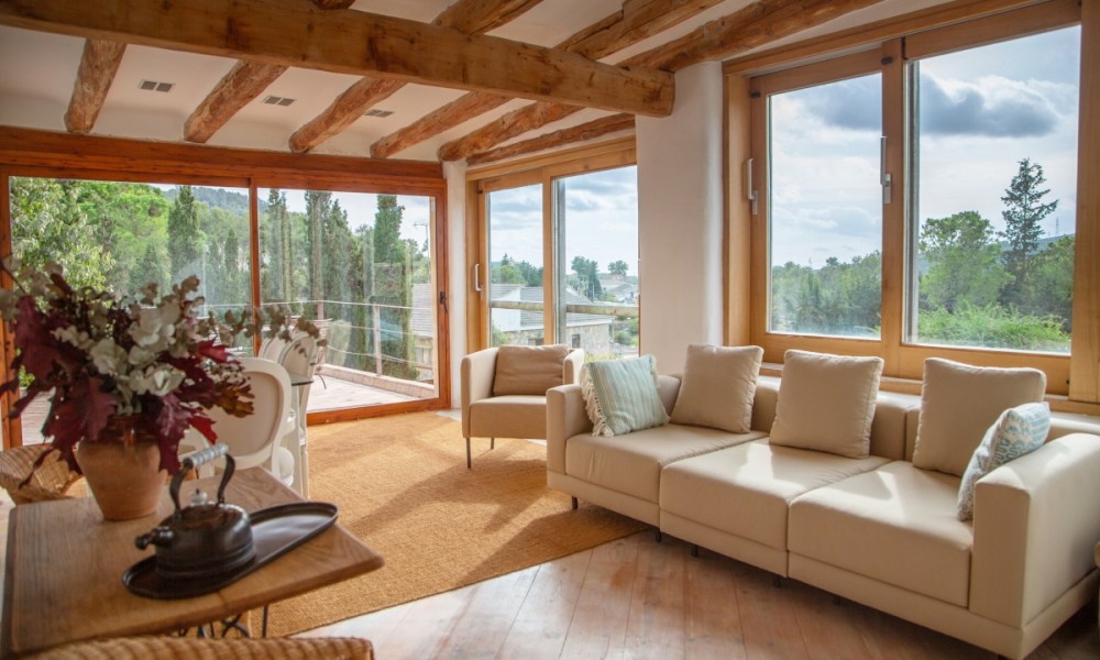 Rustic Mediterranean living room with neutral colors and exposed wood beams