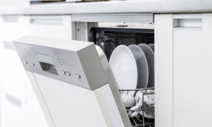 Open dishwasher in kitchen with clean dishes inside