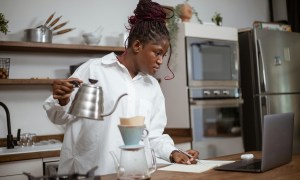 Woman in kitchen using pour over coffee maker