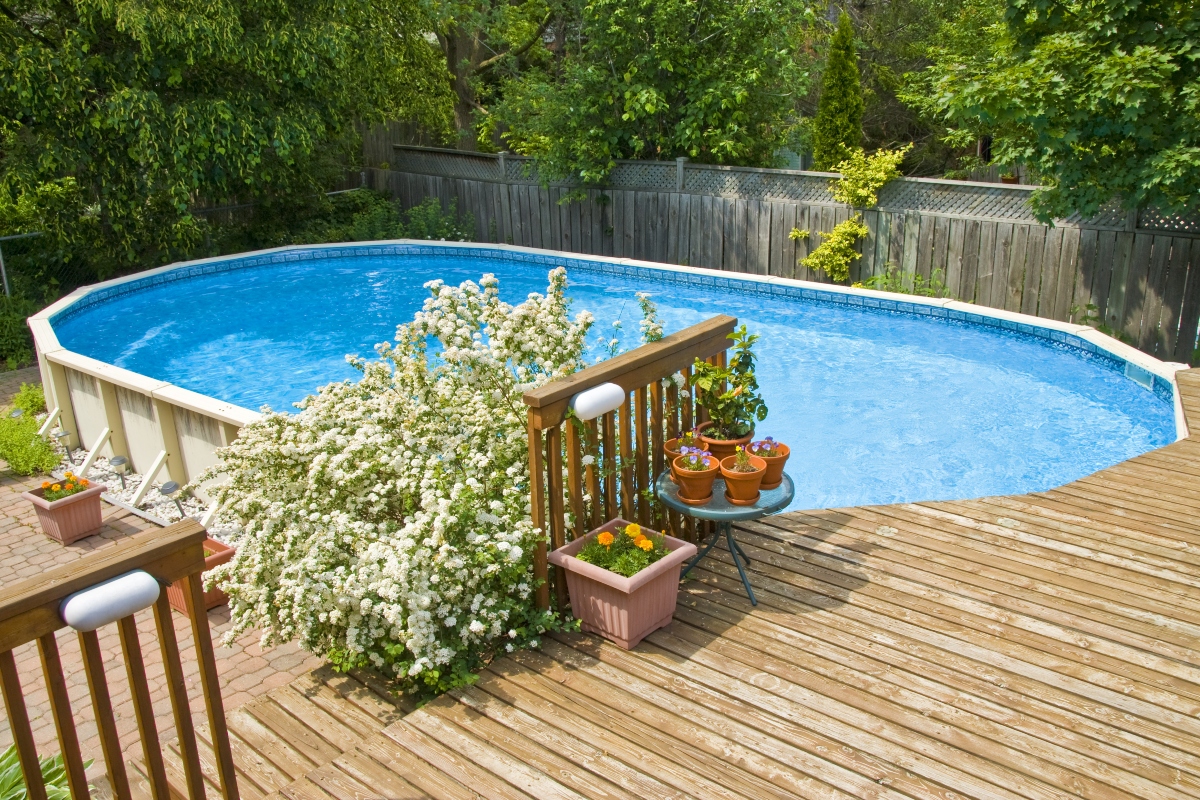 Above-ground pool with partial deck in backyard