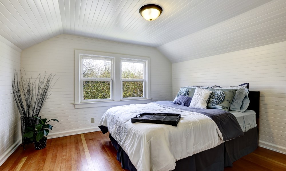 coastal bedroom design with all white interior and beadboard ceiling