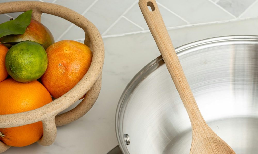 Stainless steel pan next to citrus fruit