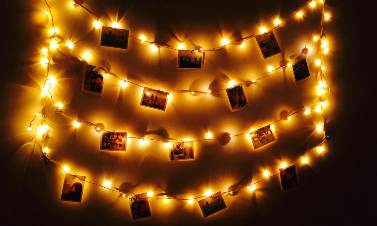 Fairy lights hung with photos on a wall