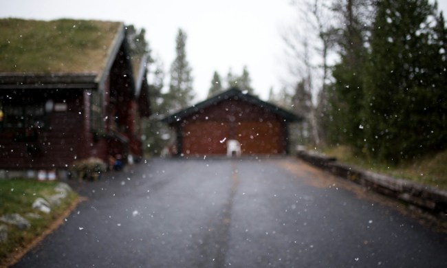 Unfocused shot of snow falling on driveway with garage in the background